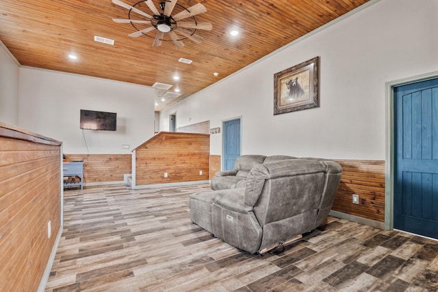 living room featuring wainscoting, wooden ceiling, wood finished floors, and wooden walls