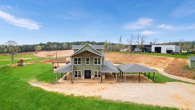 back of property featuring driveway and a yard