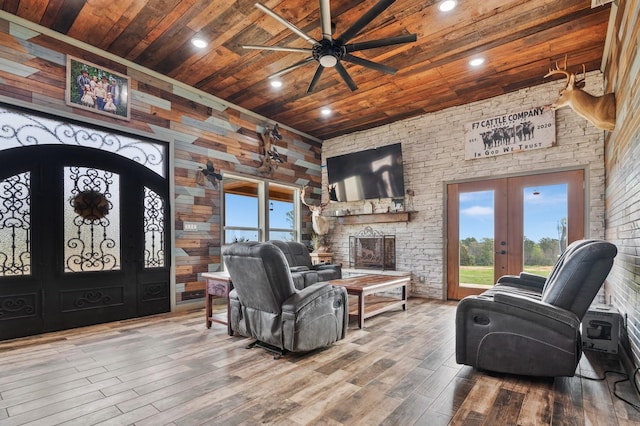 living room with plenty of natural light, wood ceiling, wood finished floors, and french doors