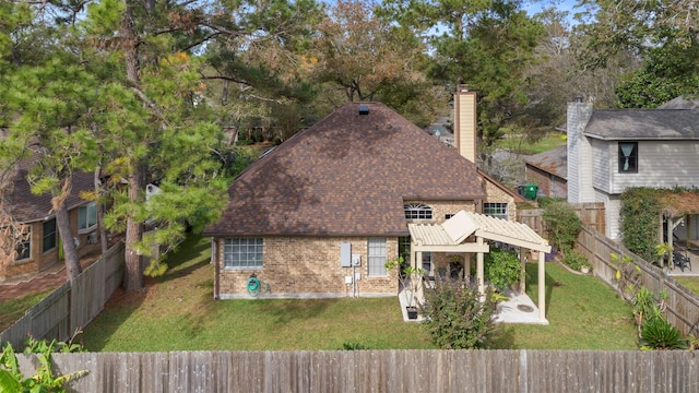 view of front of house featuring a fenced backyard, a chimney, a patio area, a front lawn, and brick siding