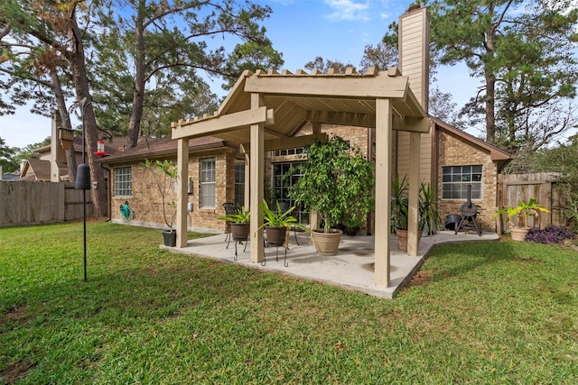 exterior space featuring a patio area, a fenced backyard, a lawn, and brick siding