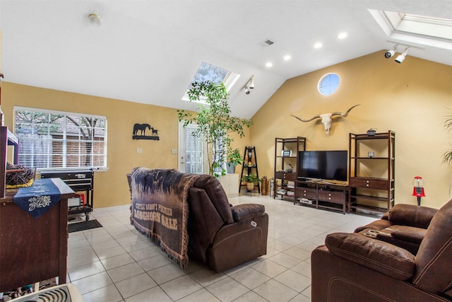 living room with vaulted ceiling with skylight, visible vents, and light tile patterned flooring