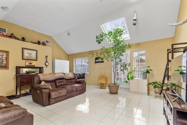 living room featuring lofted ceiling with skylight, visible vents, plenty of natural light, and light tile patterned floors