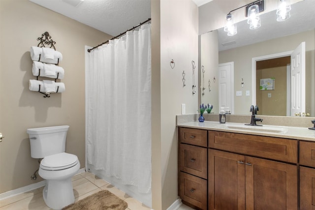 bathroom with toilet, vanity, a textured ceiling, tile patterned flooring, and baseboards