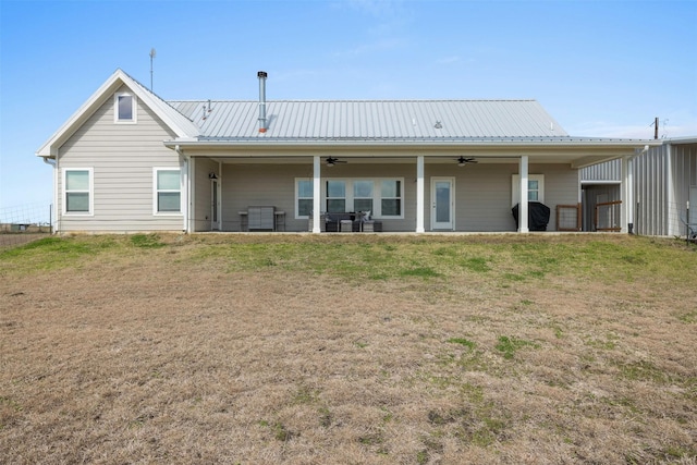 rear view of property with a patio area, metal roof, a ceiling fan, and a yard