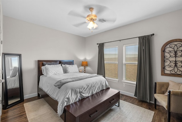 bedroom featuring a ceiling fan, baseboards, visible vents, and wood finished floors