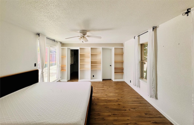 bedroom with a textured ceiling, multiple windows, wood finished floors, and access to exterior