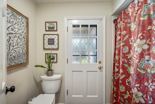 bathroom featuring toilet and a shower with curtain