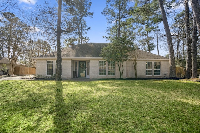 ranch-style home with brick siding, fence, and a front yard