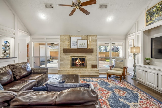 living room with lofted ceiling, visible vents, and a fireplace