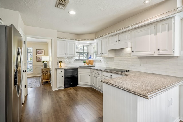 kitchen featuring visible vents, dark wood-style flooring, a peninsula, black appliances, and white cabinetry