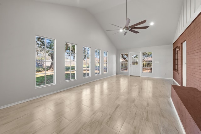 unfurnished living room with high vaulted ceiling, ceiling fan, and baseboards