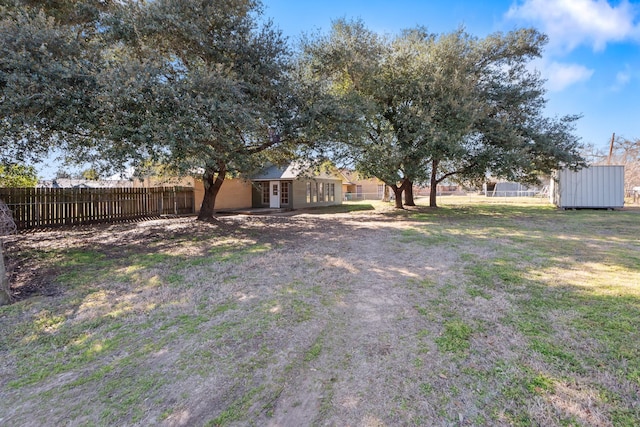 view of yard featuring an outbuilding and fence