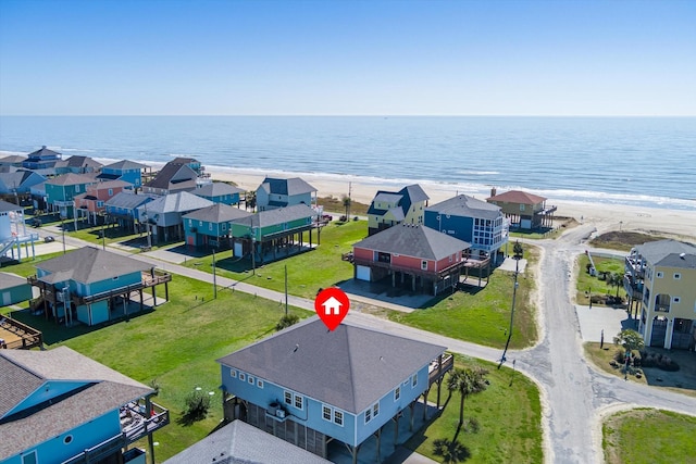 birds eye view of property featuring a water view, a residential view, and a beach view