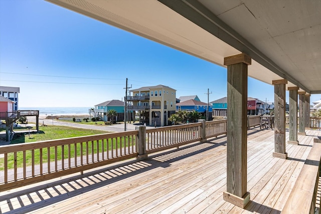 wooden terrace featuring a residential view and a water view