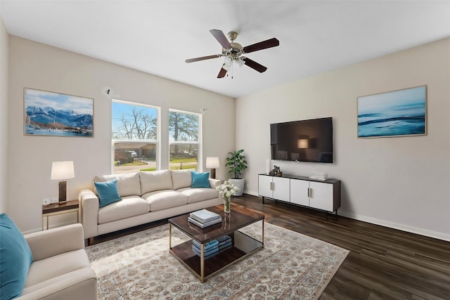 living area featuring dark wood finished floors, a ceiling fan, and baseboards