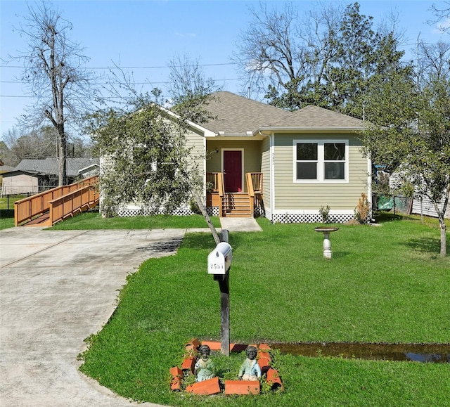 bungalow with roof with shingles, fence, and a front lawn