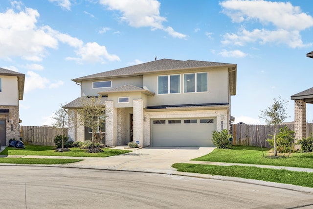 prairie-style house featuring driveway, a garage, fence, and stucco siding