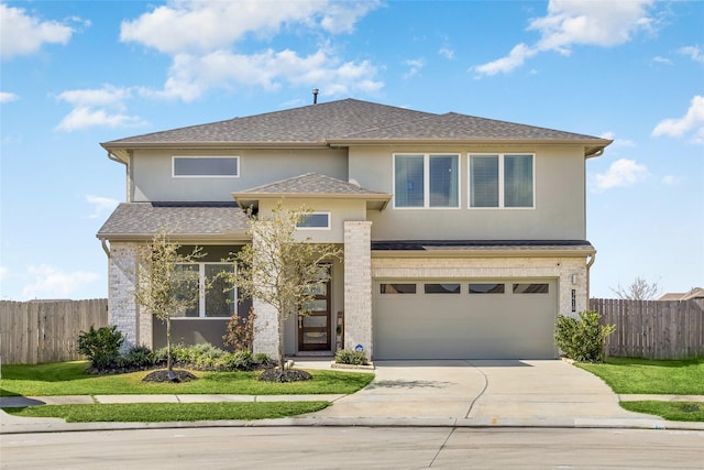 prairie-style home featuring a garage, concrete driveway, fence, and stucco siding