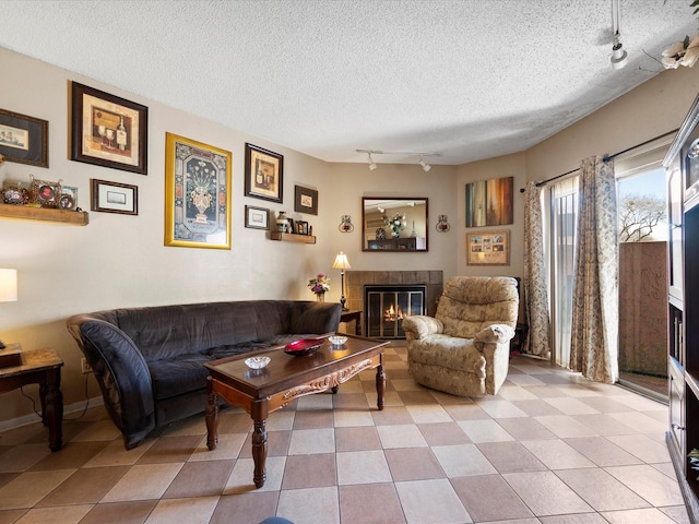 living area featuring a textured ceiling, a fireplace, and rail lighting