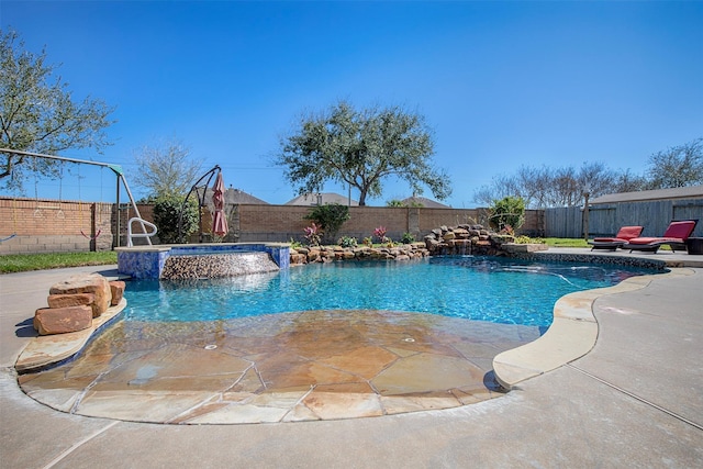 view of swimming pool with a patio area, a fenced backyard, and a pool with connected hot tub