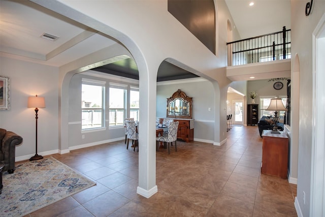 tiled foyer with arched walkways, recessed lighting, visible vents, baseboards, and a tray ceiling