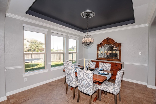 tiled dining space with crown molding, a tray ceiling, a notable chandelier, and baseboards