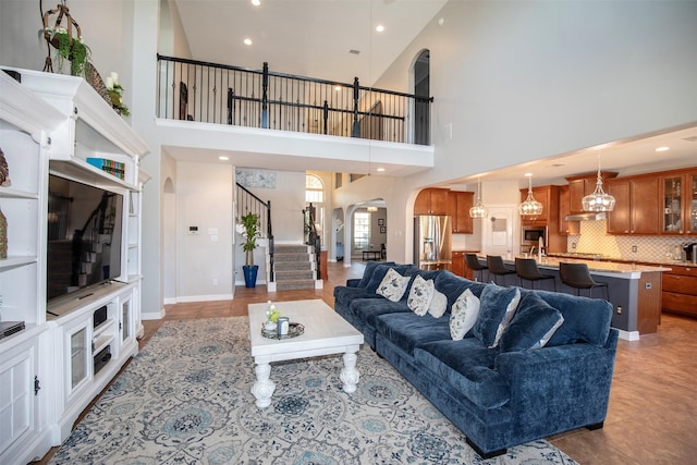 living room with recessed lighting, baseboards, arched walkways, stairway, and light tile patterned flooring