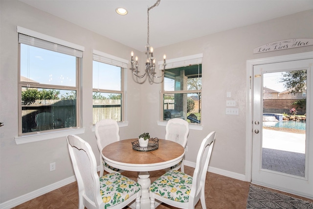 dining space with plenty of natural light, a chandelier, and baseboards