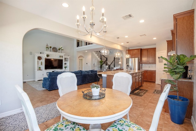 dining room featuring visible vents, arched walkways, stairway, a chandelier, and recessed lighting