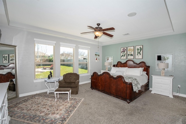 carpeted bedroom featuring baseboards, visible vents, ceiling fan, and a tray ceiling