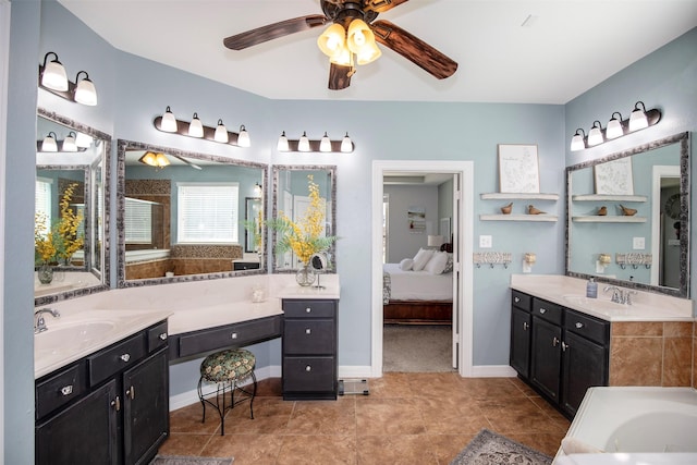 bathroom with a ceiling fan, connected bathroom, a sink, and tile patterned floors