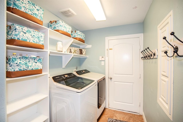 laundry area with laundry area, visible vents, and washing machine and clothes dryer