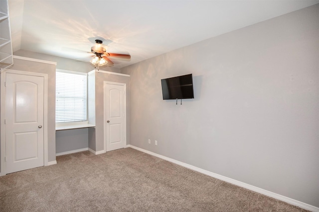 unfurnished bedroom with light carpet, baseboards, and a ceiling fan