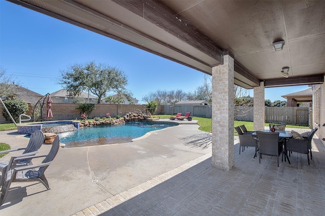 view of pool with outdoor dining area, a patio area, a pool with connected hot tub, and a fenced backyard