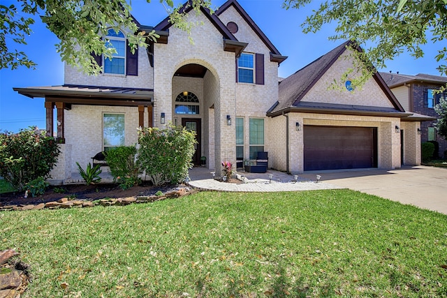 view of front facade featuring an attached garage, driveway, brick siding, and a front yard