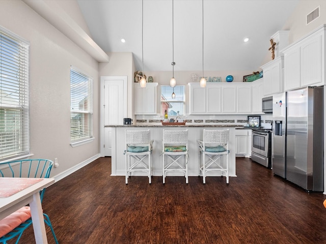 1922 Blue Water Hwy, Surfside Beach, TX 77541 - kitchen featuring appliances with stainless steel finishes, white cabinets, dark wood-style flooring, a breakfast bar area, and recessed lighting