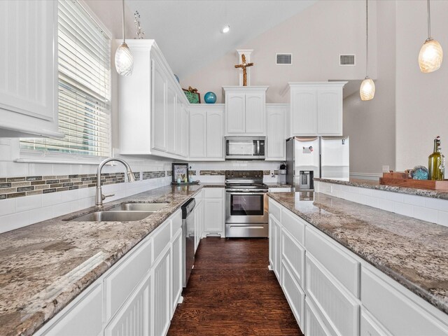 1922 Blue Water Hwy, Surfside Beach, TX 77541 - kitchen featuring stainless steel appliances, a sink, decorative backsplash, white cabinetry, and light stone countertops