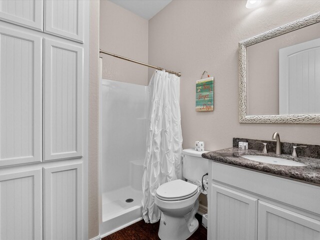 1922 Blue Water Hwy, Surfside Beach, TX 77541 - full bath featuring vanity, a shower with shower curtain, toilet, and wood finished floors