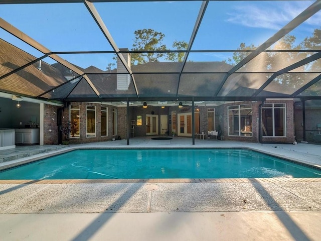 pool with french doors, a patio, a lanai, and ceiling fan