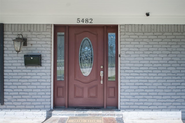 view of exterior entry with brick siding