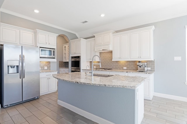 kitchen featuring stainless steel appliances, visible vents, light stone counters, and tasteful backsplash