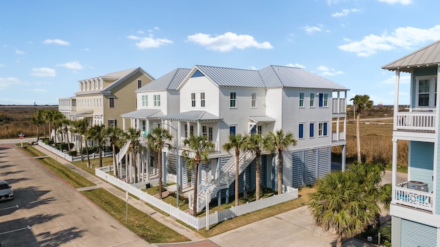 coastal home featuring a standing seam roof, a residential view, and metal roof