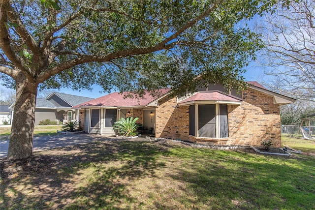 single story home with a garage, a front yard, fence, and brick siding