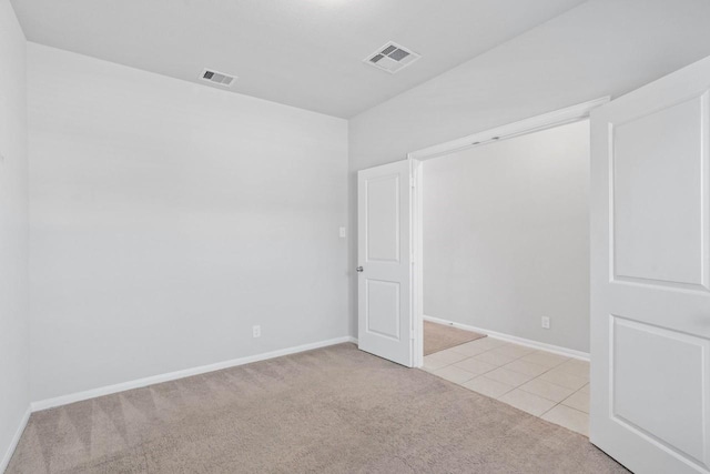 unfurnished room featuring light colored carpet, visible vents, and baseboards