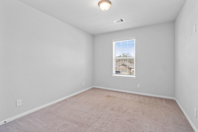 unfurnished room featuring baseboards, visible vents, and light colored carpet