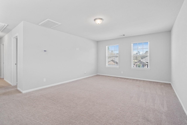 carpeted spare room featuring visible vents and baseboards