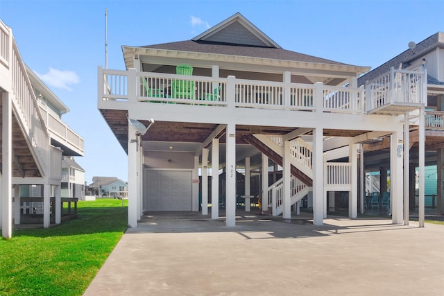 view of front facade with driveway, roof with shingles, a carport, and a front yard