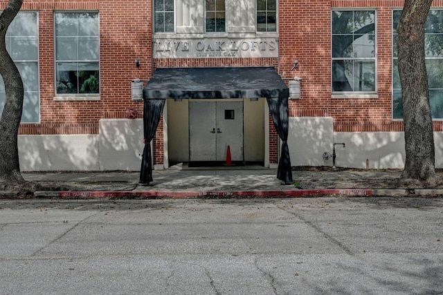 view of exterior entry with brick siding