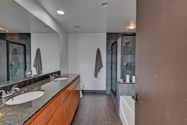 bathroom with a shower stall, a sink, and wood finished floors